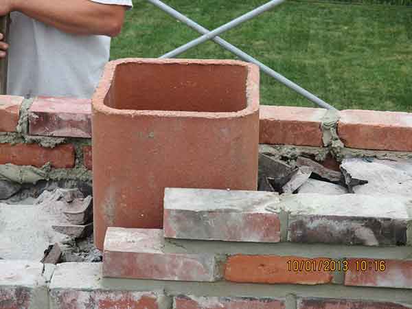 Chimney Crown Repairs flu  new mortar and bricks being installed 