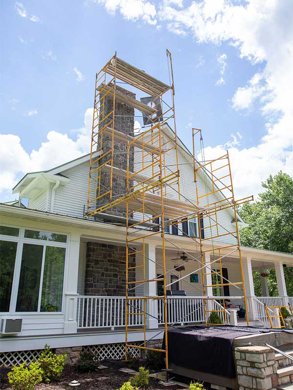 Chimney Construction Scaffolding in front of chimney white two story house