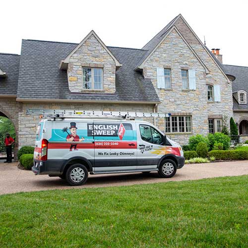 English Sweep truck in front of stone home with three peaks