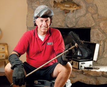 Gregg Boss with Chimney Brush sitting on limestone hearth with visual inspection tools and Logo on shirt-English Sweep Valley Park MO 