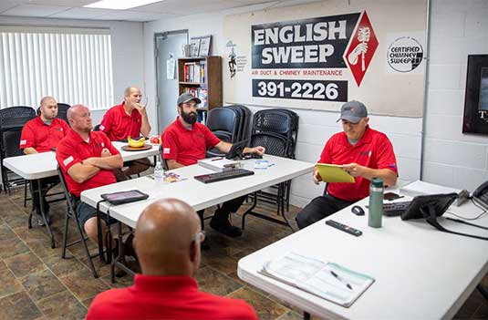English Sweep meeting three tables six men.