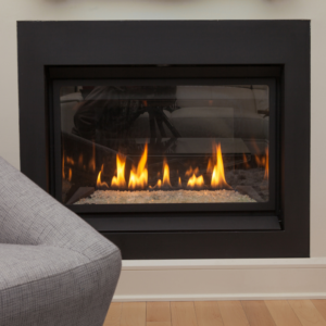 a gas fireplace insert with a chair in front of it