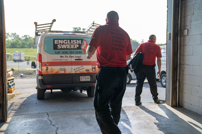 English Sweep van sitting outside company building. Two technicians walking towards the vans