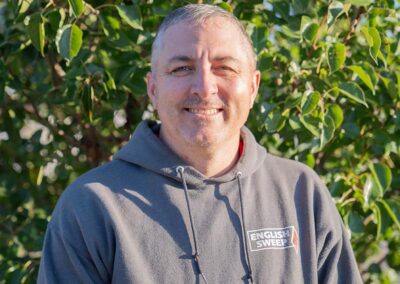Jeff N. - Sales & Service Coach has short gray hair and mustahe with a nice smile. He is wearing an English Sweep hooded pullover.
